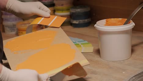 a worker applies a paint sample to a palette for color verification