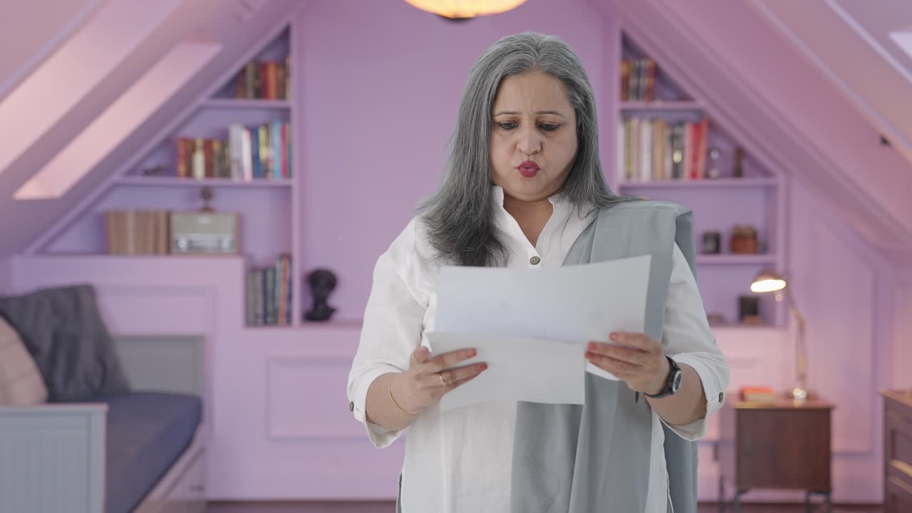 una anciana india confundida leyendo informes.