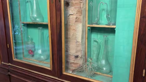 close-up of ampoules in santa maria novella pharmacy, tilt up inside closet