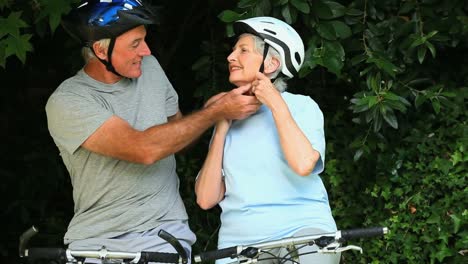 Elderly-couple-with-bikes-tying-their-helmets