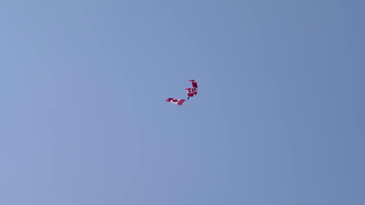 Two Canadian flags flying in the sky