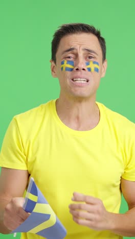 Man cheering for Sweden during a match that is lost