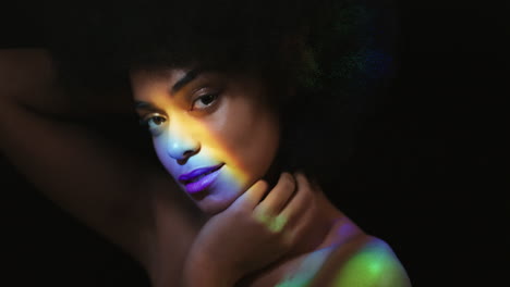 Farbenfrohes-Porträt-Einer-Schönen-Afroamerikanischen-Frau,-Die-Ihr-Gesicht-Mit-Der-Hand-Berührt,-Glatte,-Gesunde-Haut-Streichelt-Und-Die-Schönheit-Der-Natürlichen-Hautpflege-Genießt,-Die-Auf-Schwarzem-Hintergrund-Selbstbewusst-Aussieht