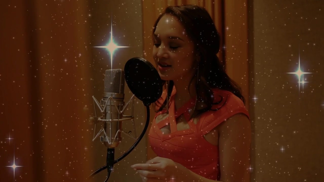 Video verticale: Cantante che legge un gobbo, canta in un microfono in studio, con una sovrapposizione stellata che brilla sopra.