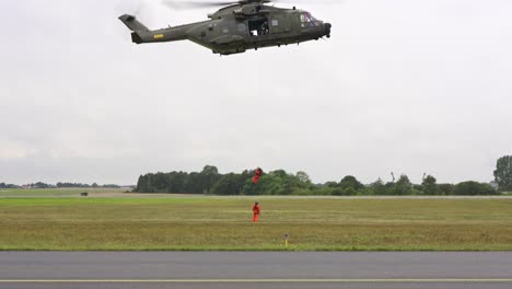 rescue helicopter crew rescuing ground  crew via wire lifting