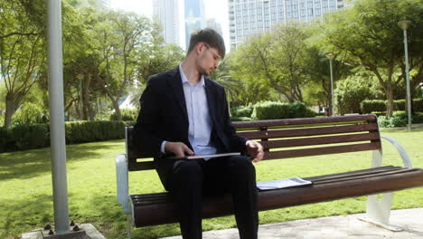 Man-sitting-on-the-bench-of-a-park