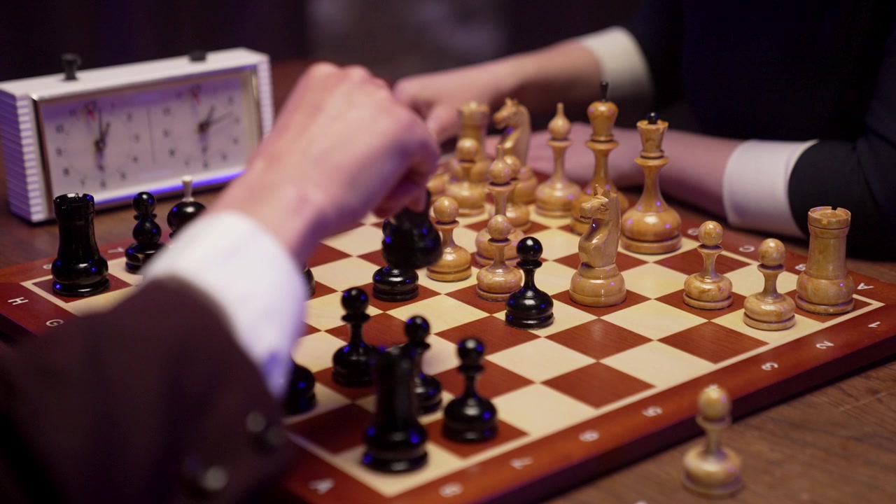 Gros plan sur des mains déplaçant des pièces d'échecs pendant une partie