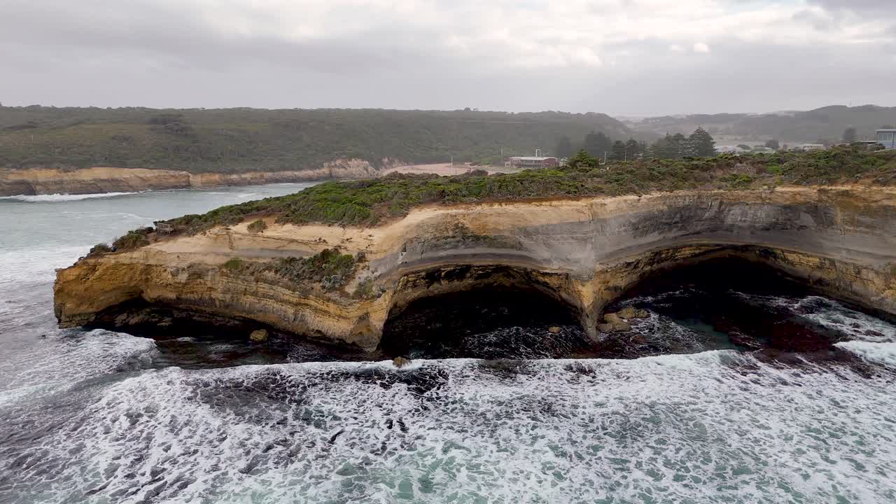 Aerial view of rugged coastal cliffs and ocean waves at Port Campbell, Australia, captured in overcast lighting