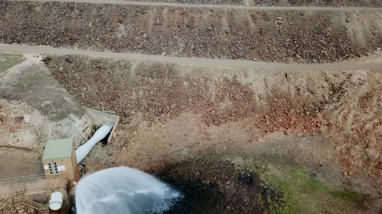 Drone footage moving upwards of the dam wall, water outlet and water tower at Lake Nillahcootie, Victoria, Australia