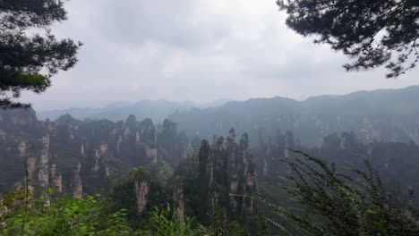 static shot of rugged sandstone pinnacles shrouded in clouds at zhangjiajie national forest park