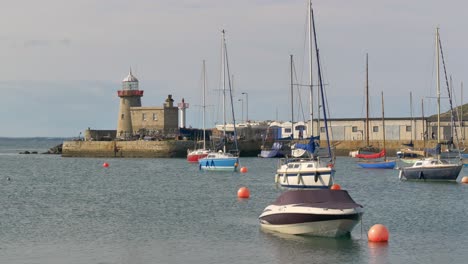 Howth-light-house-with-yachts-and-open-ocean-boats-anchored-off-shore-front-in-harbor