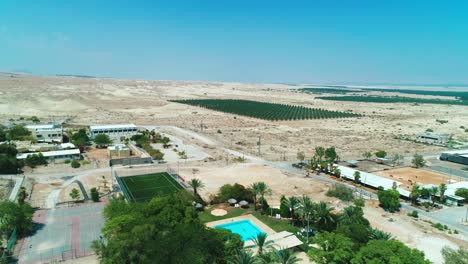 drone shot of a kibbutz and a palm tree field in the desert