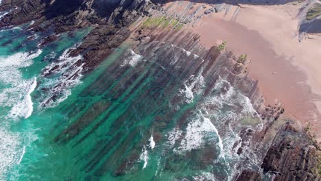 waves crashing and water washing on ridges of soar cliff, playa de tagle
