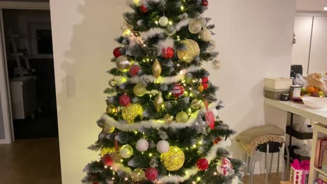 flashing colourful christmas garland on the tree, round plastic balls and toys hanging on branches