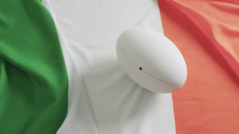 White-rugby-ball-over-flag-of-ireland-with-copy-space,-in-slow-motion