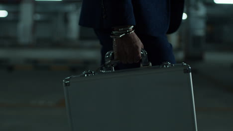 businessman carrying briefcase in underground parking garage