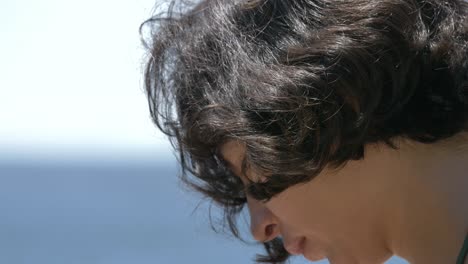 close up of girl face filming sea scenery with smartphone