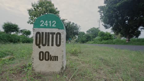 hito de carretera que muestra la distancia de quito