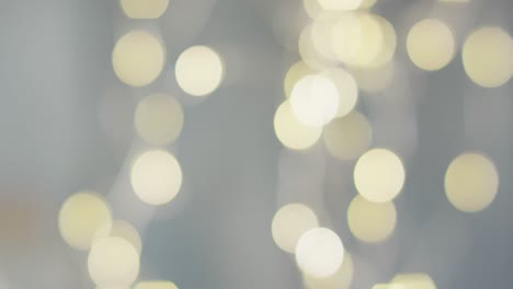 Video-of-close-up-of-bokeh-christmas-fairy-lights-on-grey-background