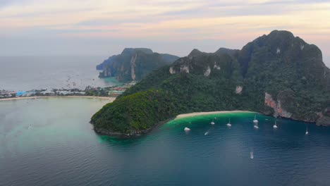 Aerial-view-of-small-islands-with-hills-and-jungle-surrounded-by-paradisiac-beaches-in-Phuket-at-sunset