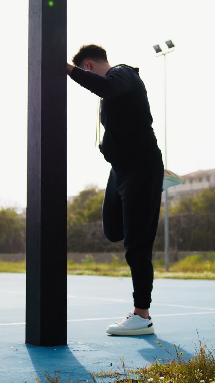 Basketball Player Prepares for the Match at the Park by Stretching