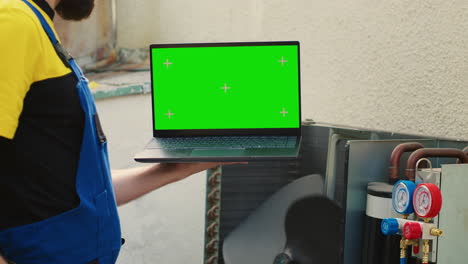 worker with green screen laptop