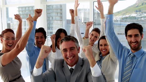 un equipo de negocios emocionado aplaudiendo a la cámara.