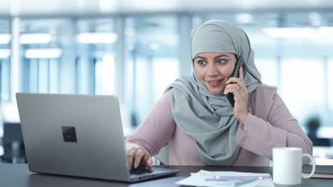 happy muslim businesswoman talking on phone