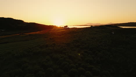 sunset over a campervan on a hilltop