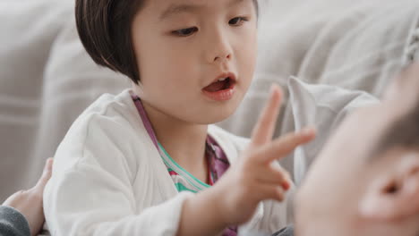 아버지와 함께 아름다운 작은 아시아 소녀가 집에서 딸과 함께 놀고 있는 가족 시간을 보내고 있습니다.