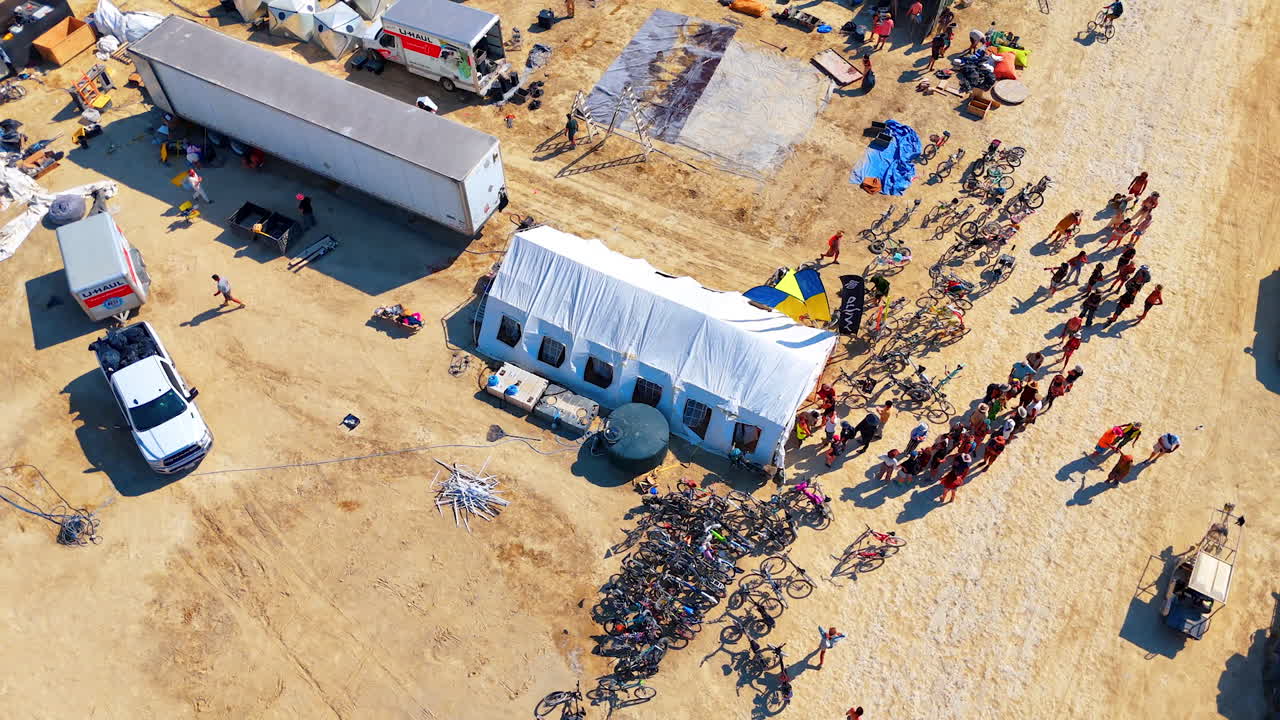 Nevada, USA, 22 August 2025: Queue of bicycles and tents at Burning Man camp. Aerial view of tents, bicycles and people standing in a line at Burning Man festival camp in Nevada desert