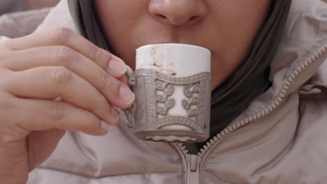 una mujer bebe café y come chocolate