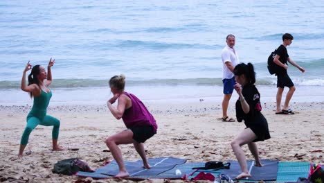 personas practicando yoga en una playa pintoresca