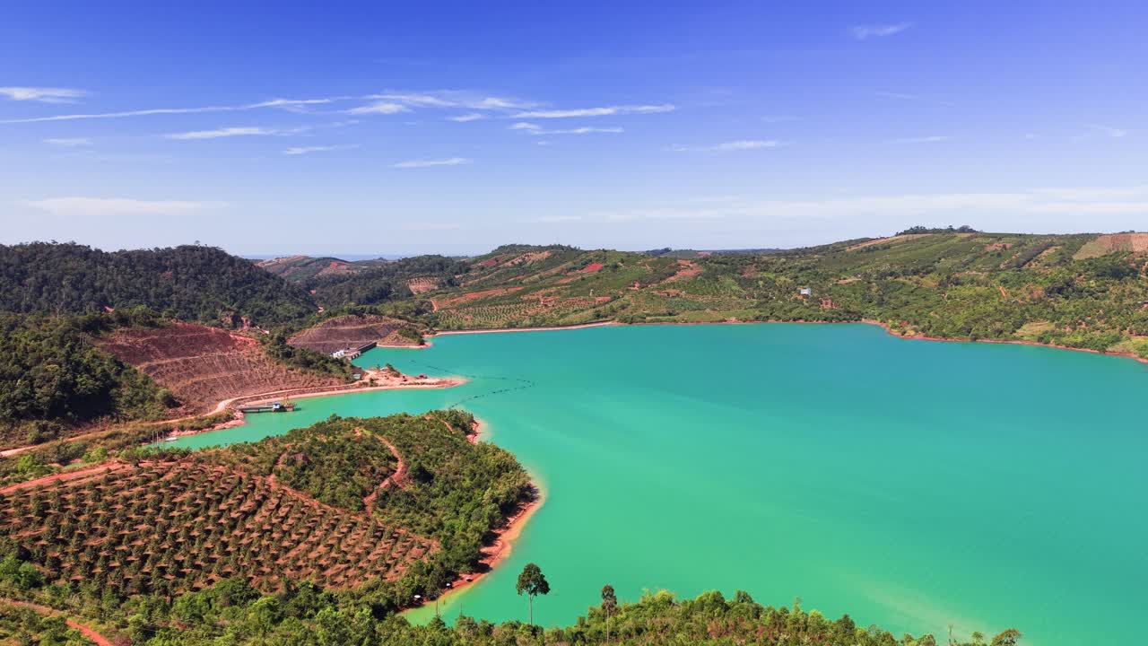 Isso mostra campos verdes e fileiras de colheitas bem arrumadas em Lam Dong, Vietnã. Caminhos de terra serpenteiam pelos campos sob o céu claro. Fazendas cultivam várias plantas nesta área
