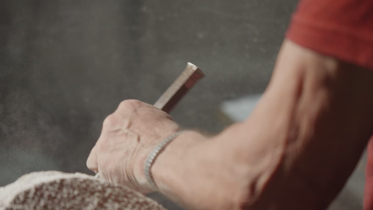 Close-up view about the chiseling stone work details with a working man hand, Italy.