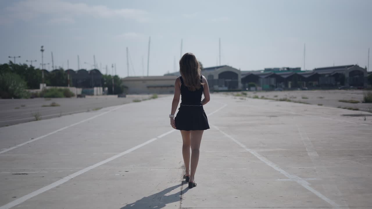 誰もいない街の通りを一人で歩く女性