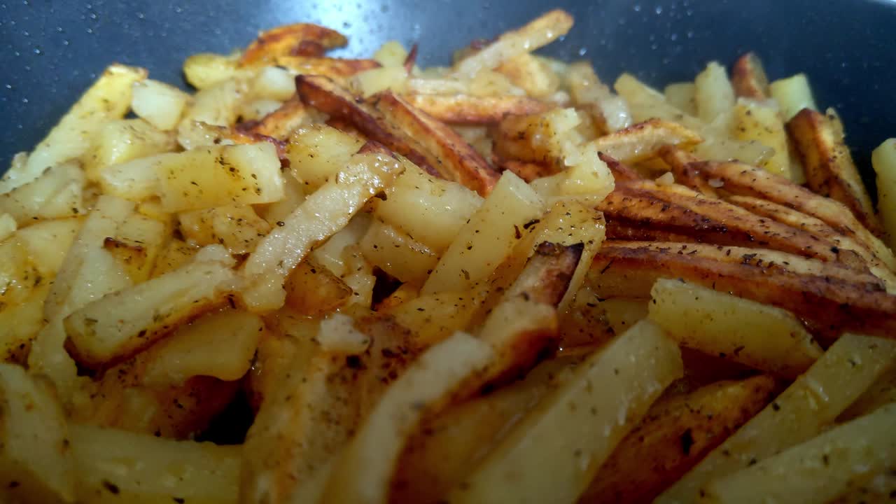Close-up of fried potatoes in a frying pan