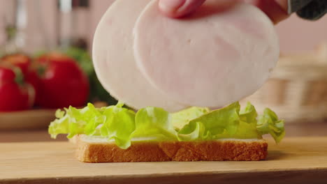 making a ham and lettuce sandwich