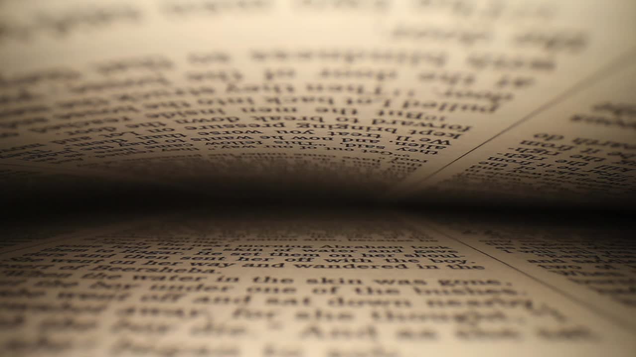 moving laterally through Bible right to left, pages on top - bottom of frame as it passes down to the end