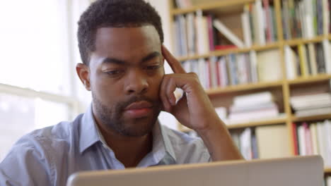 businessman using laptop at desk in busy office shot on r3d