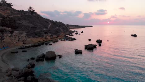 aerial rising shot from the beach to the sky over konnos bay at sunset