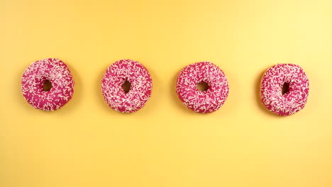 sharing pink donuts with sprinkles