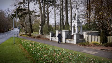 Lady-walker-passes-memorial-to-James-Mitchell---The-Carrier---in-Kemnay-Aberdeenshire