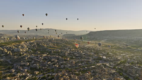 göreme turquía aérea v70 mágica vista dorada del amanecer, sitio de roca elevada que captura la formación de campos de meseta y chimeneas de hadas, con globos aerostáticos en el cielo - filmada con cine mavic 3 - julio de 2022