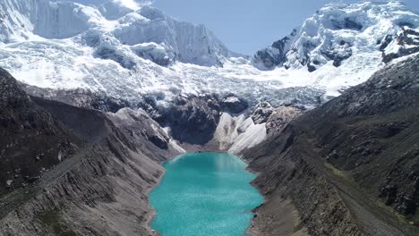 “a breathtaking turquoise glacial lake surrounded by rugged andean peaks and pristine snow. ideal for travel blogs, nature videos, and adventure videography