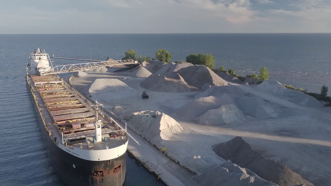 Huge Industrial Ship At The Sand Quarrying Site Surrounded By The Calm Sea In Kingsville, Ontario, Canada - Descending Drone Shot
