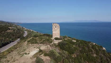 aerial circle over ruins of ancient byzantine apollonia tower by coastline, greece