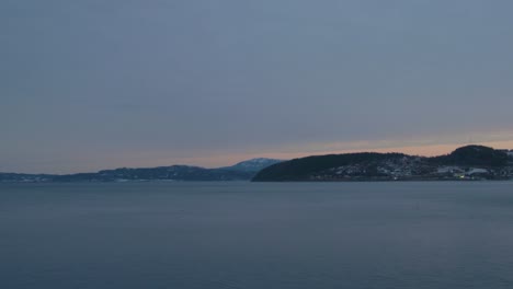sunrise over the mountains and a fjord in norway, that is shot from the moving train