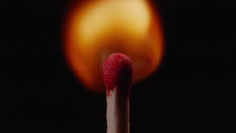 single match with rising flame isolated on black