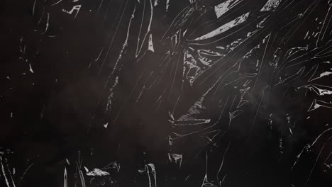 animation of fire and smoke over light on moving shiny black plastic